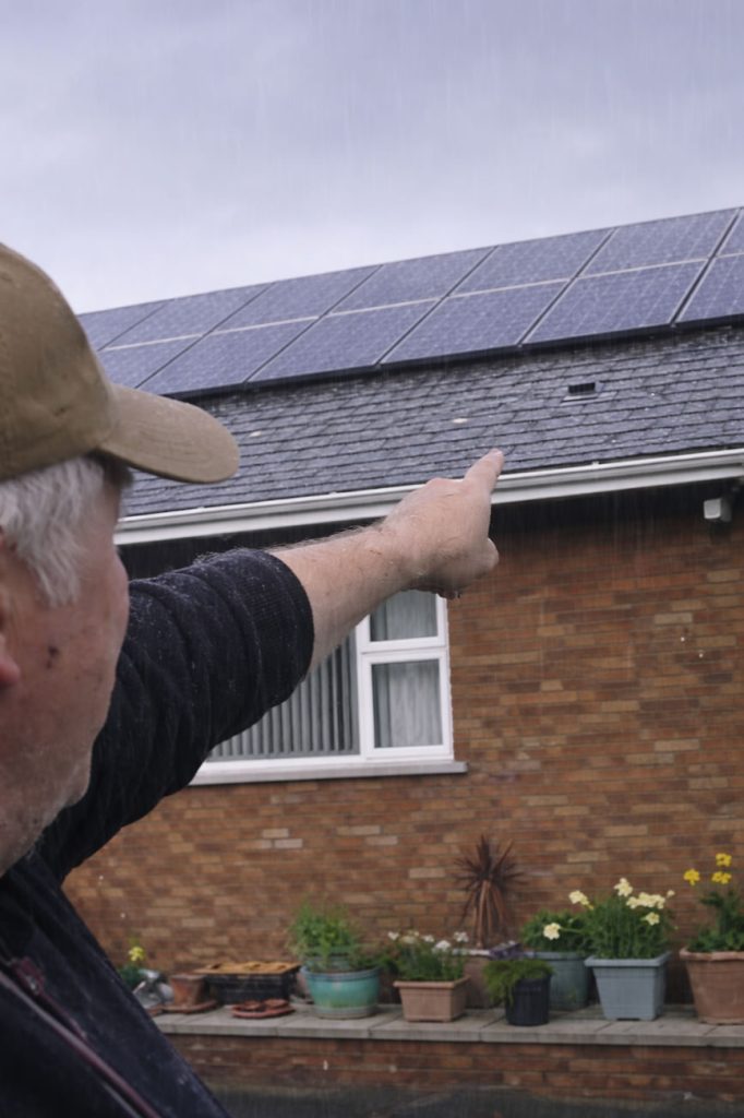 man pointing to a roof damage after stormy weather