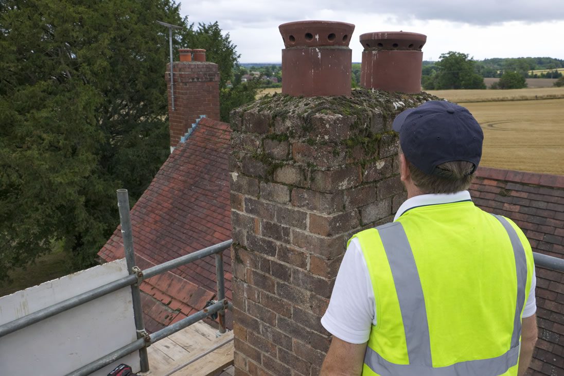 roofer looking at chimney before removal work begins